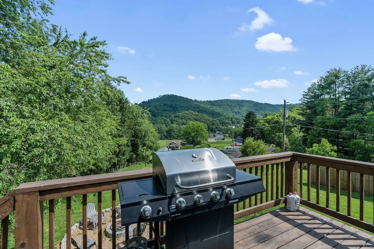 Back deck with a gas grill looking out over green mountains
